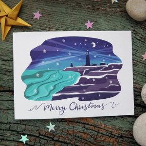 Isle of Portland Christmas Card featuring Portland Bill lighthouse, sea and cliffs at night time in the snow.